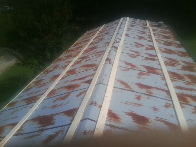 Rusted metal roof panels with new wood purlins before replacement — Storm Damage Roof Repair in Penn Yan by Roofing Brothers