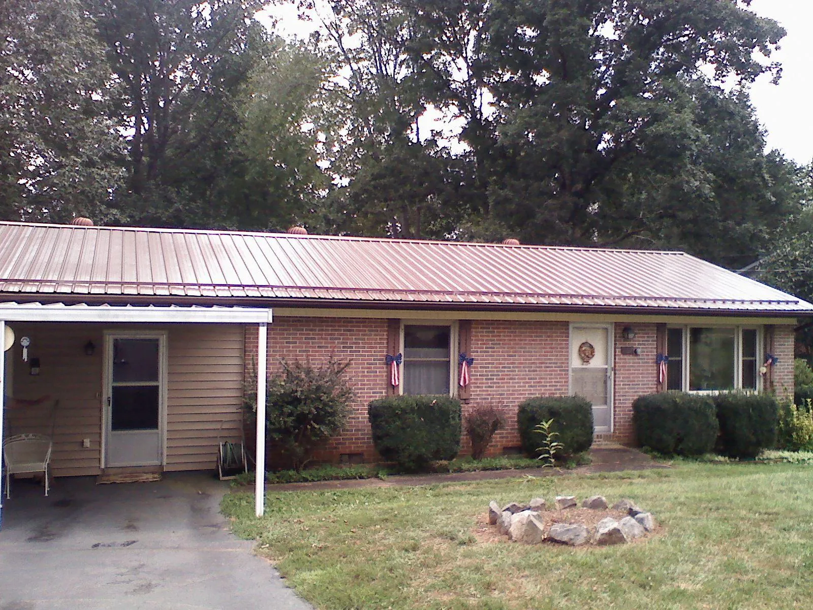 Bronze metal roof and carport on a brick ranch home — Roof Repair work by our crew in Penn Yan